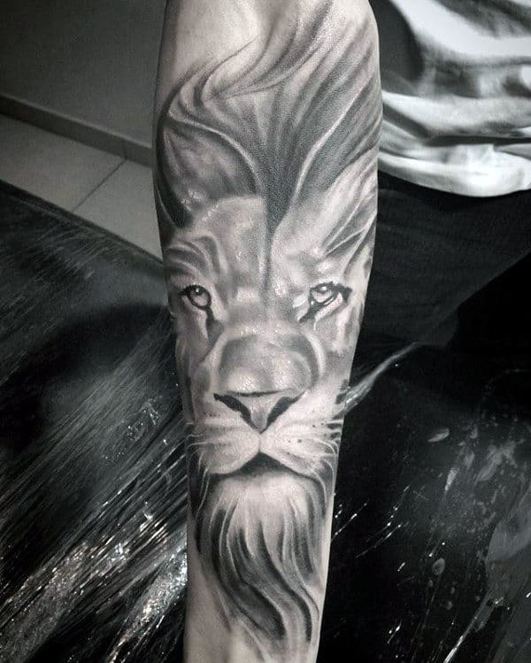 Forearm tattoo of a realistic lion's face with a flowing mane