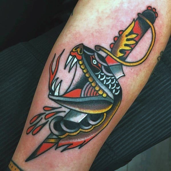 Traditional snake and dagger tattoo with bold black, red, and yellow ink, featuring fierce details and dynamic shading on the forearm.