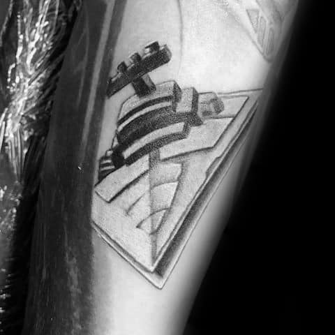 Minimalist Star Destroyer tattoo on forearm, featuring bold geometric shading and a sharp angular perspective.