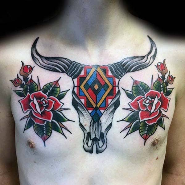Colorful bull skull and roses tattoo on a person’s chest