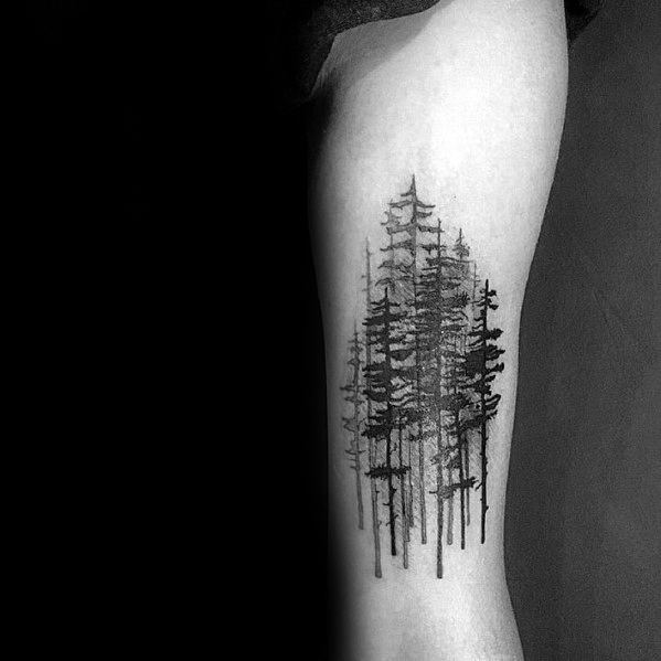 Black ink forest tattoo on the leg, featuring a cluster of tall pine trees with fine shading for a minimalist yet detailed nature-inspired design.