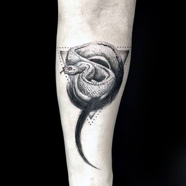 Tattoo of a coiled snake with a geometric triangle outline on an arm