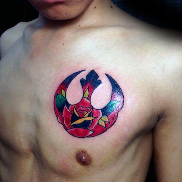 Person with an upper chest tattoo featuring a colorful rose within a Rebellion symbol outline