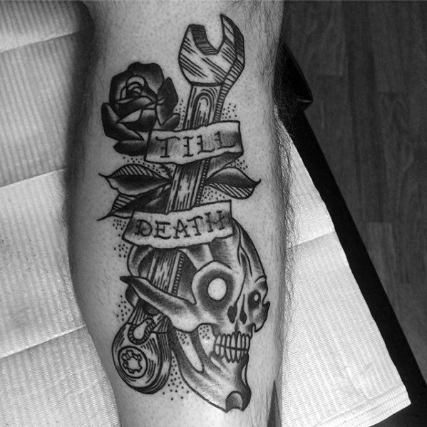Black and grey tattoo of a wrench, rose, and skull with a banner that reads TILL DEATH in bold traditional style.