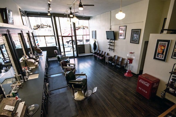 Hollywood-themed barber shop with retro decor, leather chairs, and a vintage Coca-Cola machine.