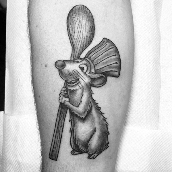 Black and grey tattoo of Remy from Ratatouille smiling and holding a wooden spoon and spatula, showcasing his love for cooking.
