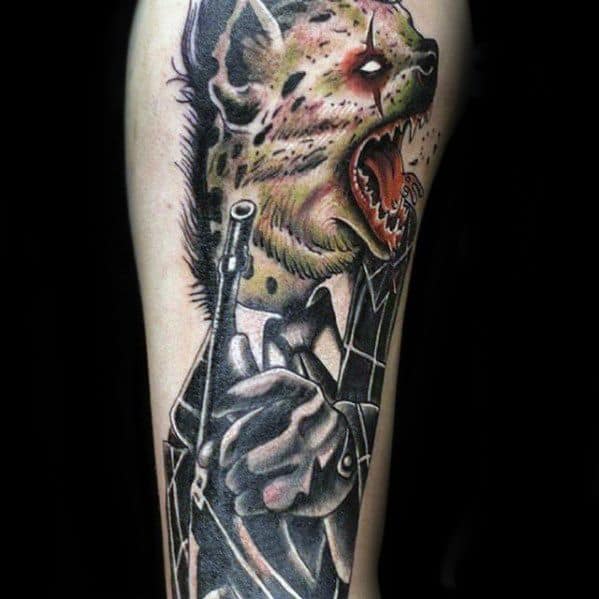 Stylized hyena tattoo with a humanoid body in a suit, holding a gun, featuring a snarling face, glowing eyes, and vivid horror-inspired details.