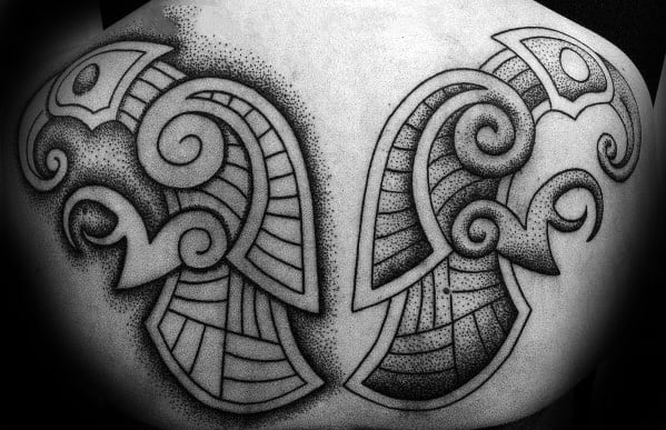 Dotwork-style tattoo of Odin’s ravens with intricate Norse patterns, mirrored across the upper back in bold black ink.