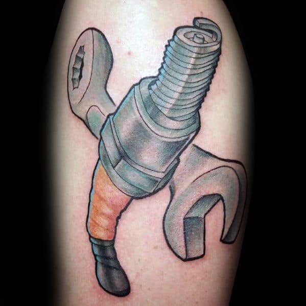 Color tattoo of a spark plug surrounded by two crossed wrenches, done in a bold, cartoon-like style.