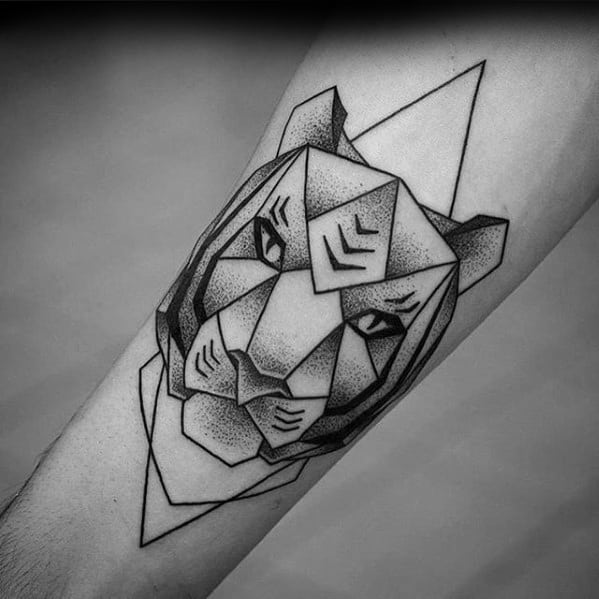 Geometric tiger face tattoo with sharp angles and dotwork shading, featuring bold eyes and layered shapes on the forearm.