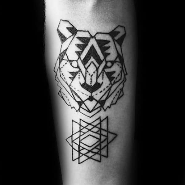 Minimalist geometric tiger face tattoo with bold linework and symmetrical patterns, paired with abstract shapes below on the forearm.