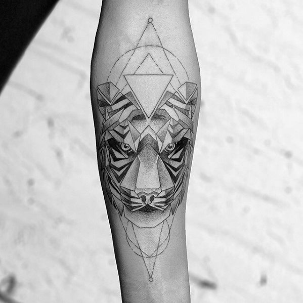 Geometric tiger tattoo on the forearm with sharp angles, piercing eyes, and layered triangle patterns forming a bold symmetrical design.