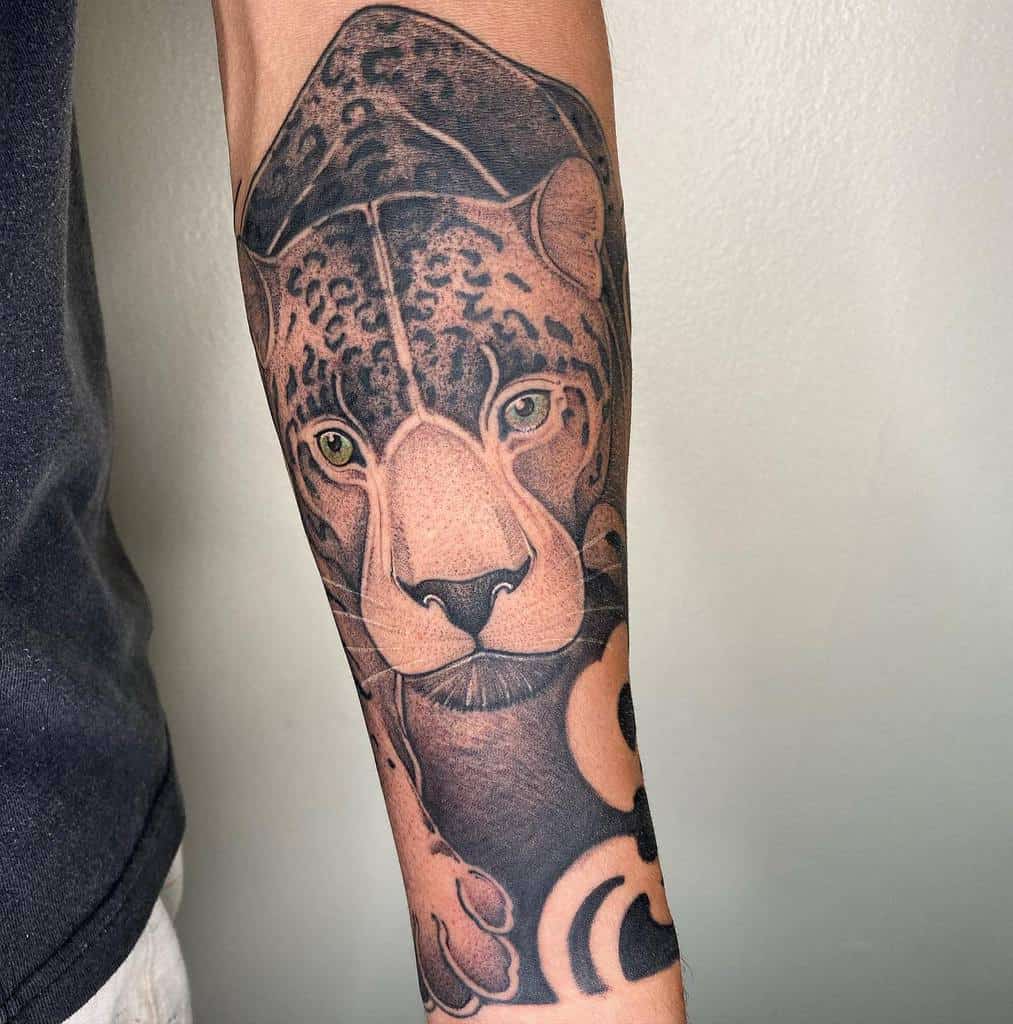 A bold and intricate jaguar tattoo covering the forearm, blending realism with geometric elements and deep shading for a striking design.