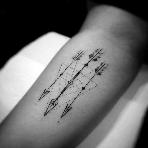 Minimalist geometric tattoo with three parallel arrows, dotted lines, and abstract diamond shapes on the upper arm.