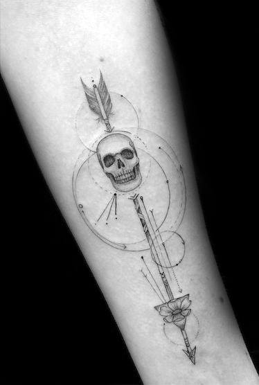 Geometric arrow tattoo featuring a skull, overlapping circles, fine lines, and a rose detail on the forearm.