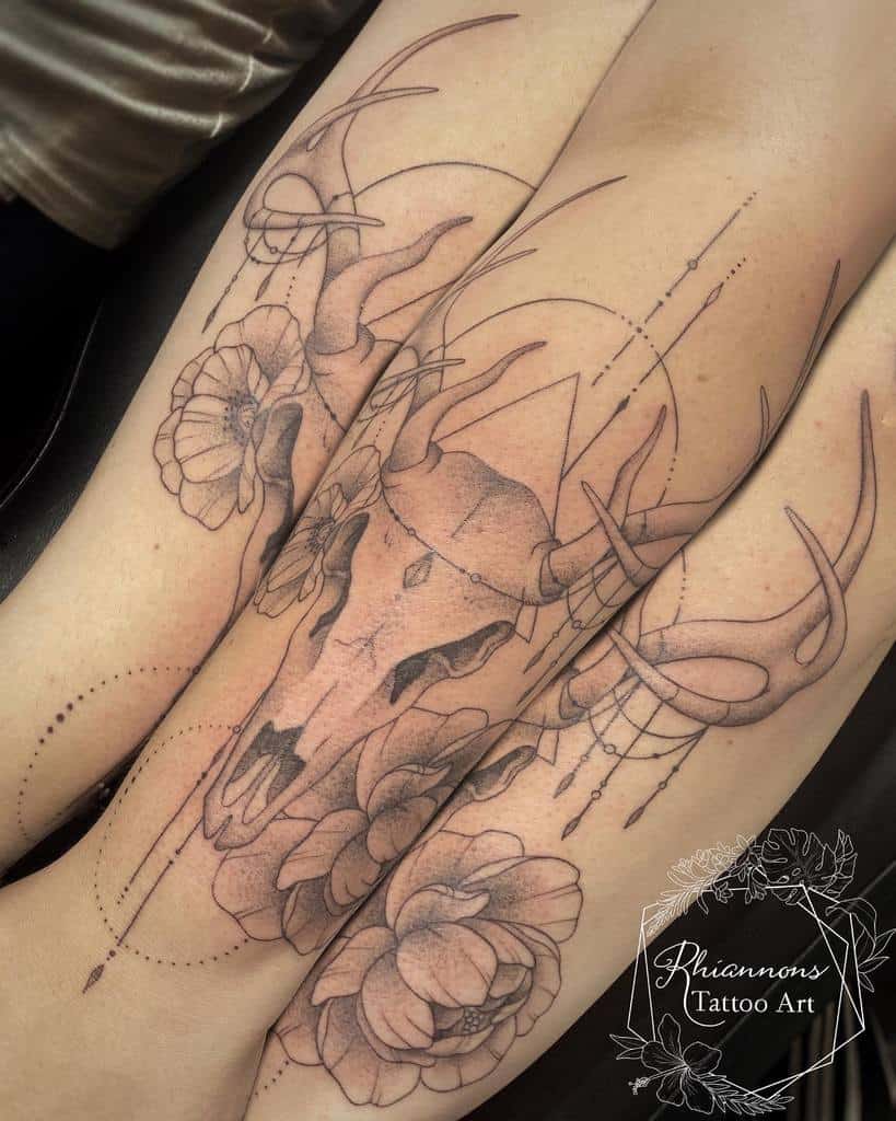 Detailed deer skull tattoo with geometric shapes, flowers, and flowing lines, creating a balance of nature and abstract design on the arm and leg