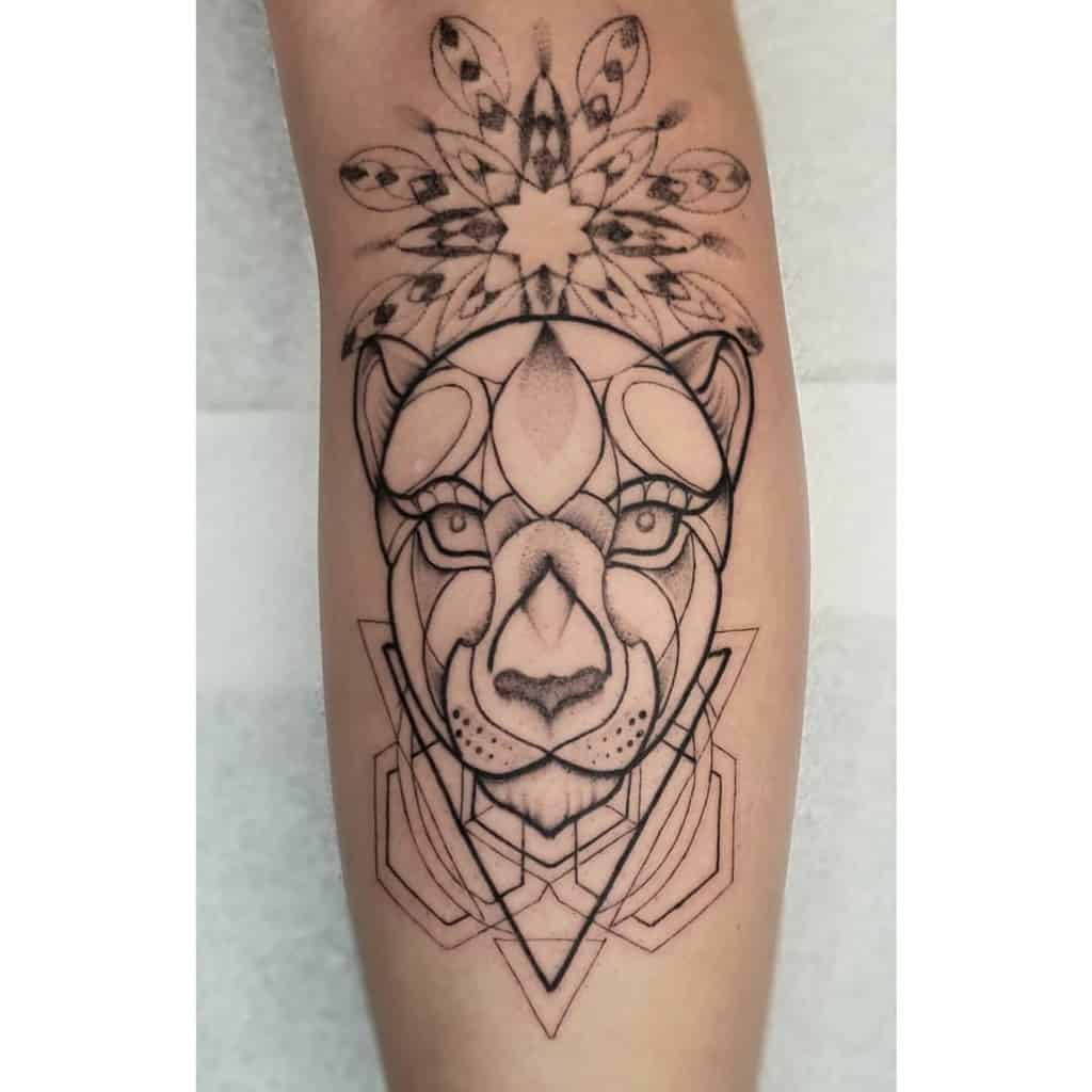 Geometric lioness tattoo on the forearm, featuring bold linework, intricate mandala elements, and symmetrical shapes for a modern look.