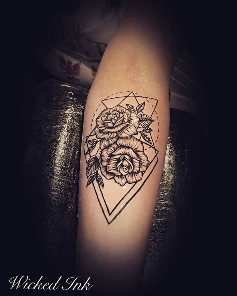 Geometric forearm tattoo featuring detailed roses within a diamond-shaped frame, blending nature and modern design
