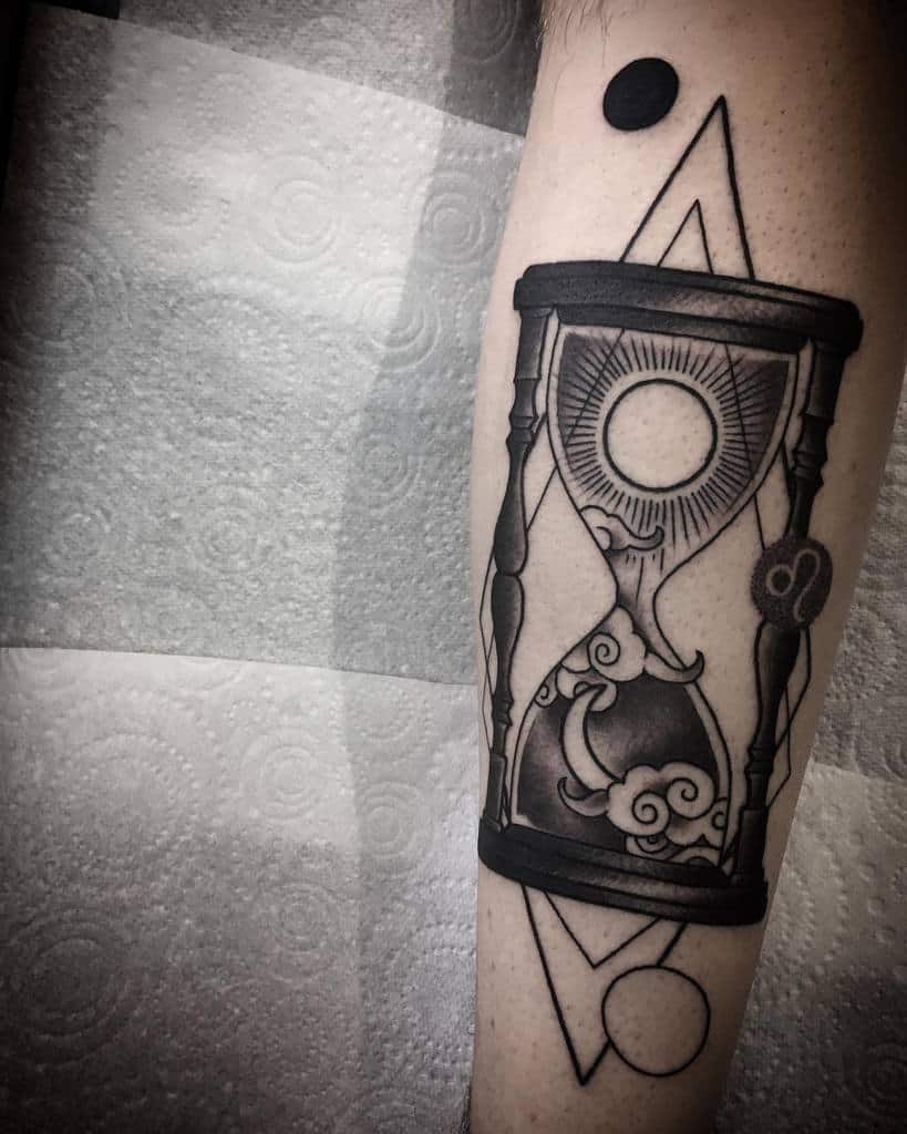 Intricate hourglass tattoo featuring celestial elements, swirling clouds, and geometric shapes for a cosmic theme.