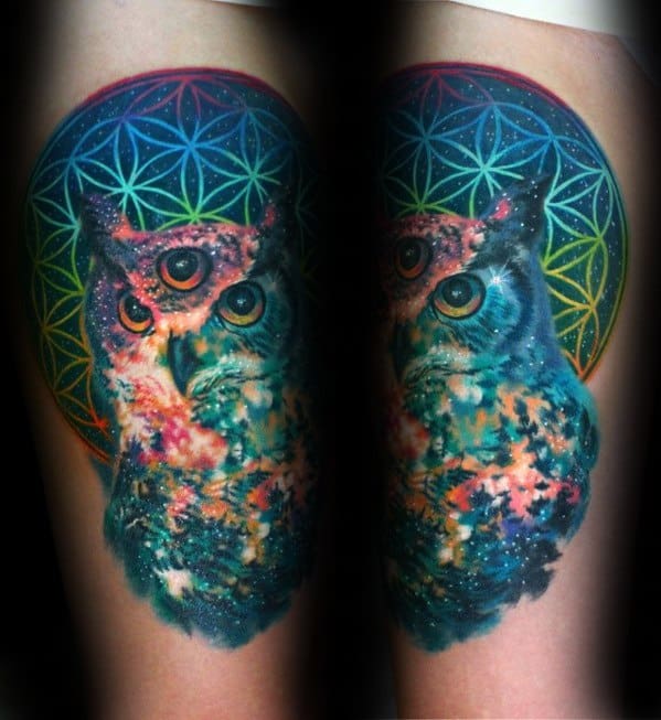 Psychedelic owl tattoo with three eyes, cosmic colors, and a geometric rainbow mandala in the background for a surreal effect.