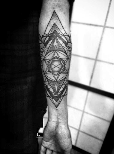 Geometric tattoo on a person's forearm, with intricate lines and patterns