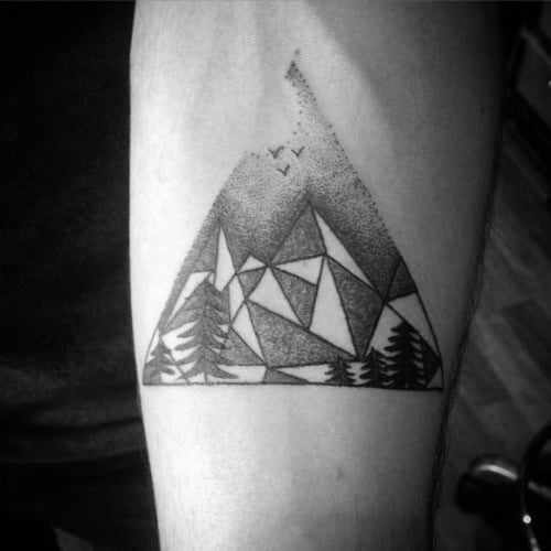 Geometric mountain tattoo with abstract triangular shapes, shaded sky, flying birds, and pine trees at the base.