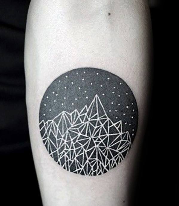 Bold circular tattoo featuring a night sky with stars and abstract geometric mountain lines in white over a black background.