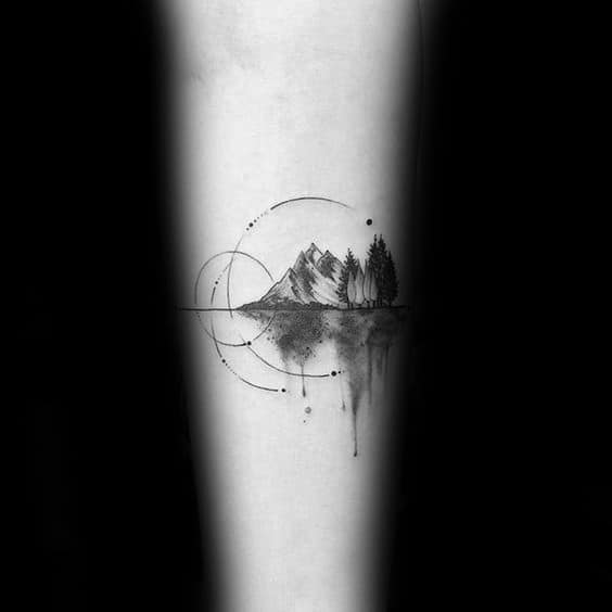 Minimalist mountain and forest tattoo with circular geometric lines and mirrored watercolor-style reflection below.