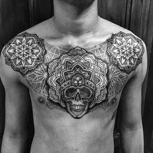 Black and grey chest tattoo featuring a central skull with sacred geometry and mandala designs, symbolizing mortality, balance, and spiritual awakening.