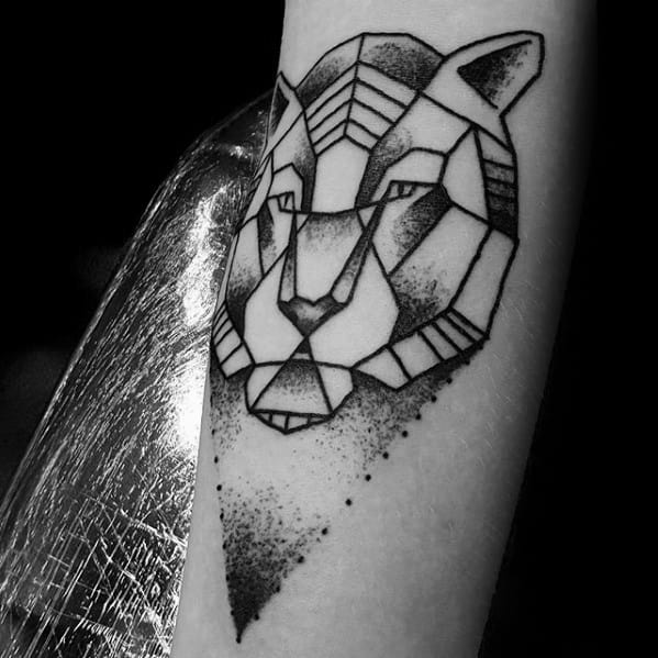 Abstract geometric tiger tattoo on forearm with bold black outlines and dotwork shading forming a triangular background.