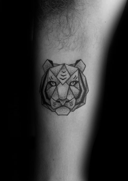 Small geometric tiger head tattoo with sharp angles and dotwork shading, placed on the inner arm for a sleek and fierce look.