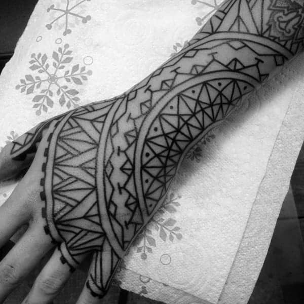 Black and white hand tattoo featuring intricate geometric patterns