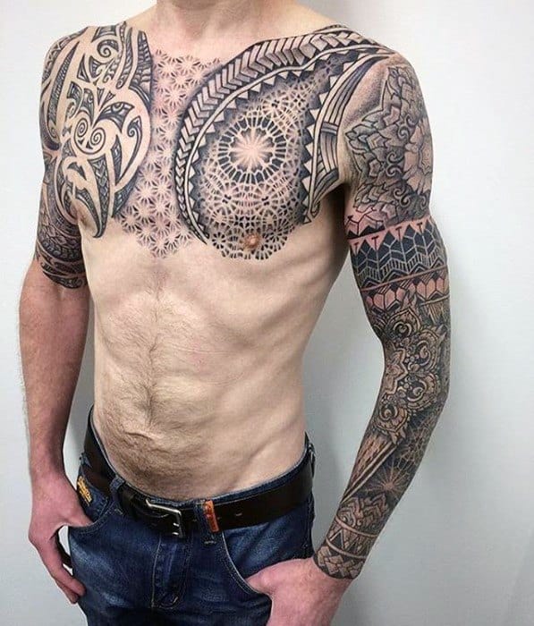 Upper body geometric chest tattoo featuring tribal designs on man's chest and upper arms