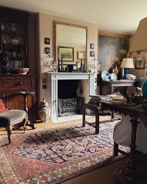 Collector’s Georgian living room with a marble fireplace, antique furnishings, and a plush Persian rug in a warm, curated setting.