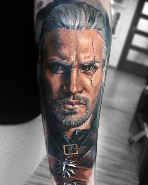 Geralt tattoo with a piercing stare, scarred face, and silver hair, featuring his signature wolf medallion and detailed armor.