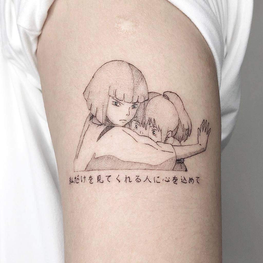 Fine-line tattoo of Haku embracing Chihiro from Spirited Away, with delicate shading and Japanese text below the design