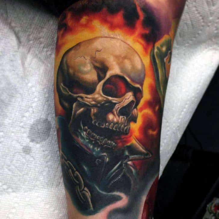 Ghost Rider tattoo with a realistic flaming skull, glowing red eyes, leather jacket, and bold chains surrounded by fiery smoke.