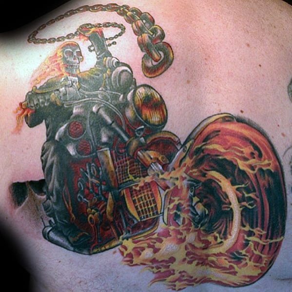 Colorful Ghost Rider tattoo with a fiery skull riding a flame-blazing motorcycle, wielding a flaming chain above his head.
