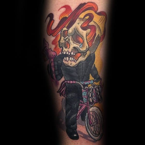 Cartoon-style Ghost Rider tattoo with a flaming skull riding a pink bicycle, dressed in black with playful and colorful details.
