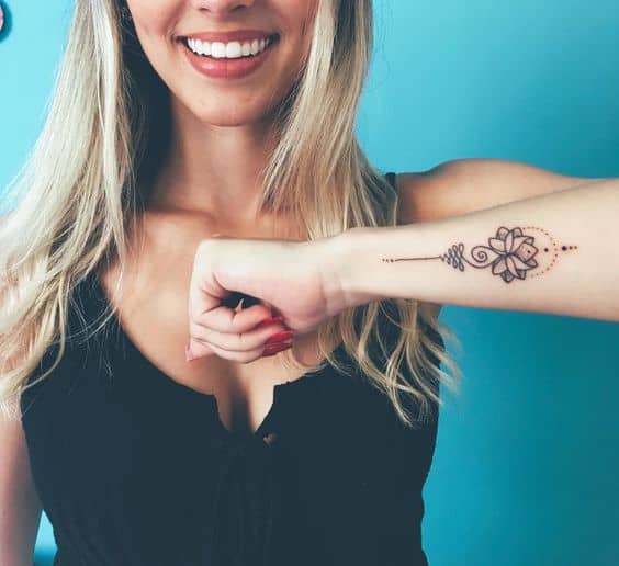Unalome tattoo with a lotus on the forearm, symbolizing spiritual growth, enlightenment, and the journey toward inner peace.