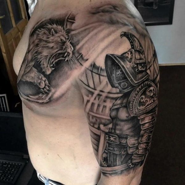 Tattoo of a fearless gladiator facing a roaring lion with detailed shading on a person's upper arm