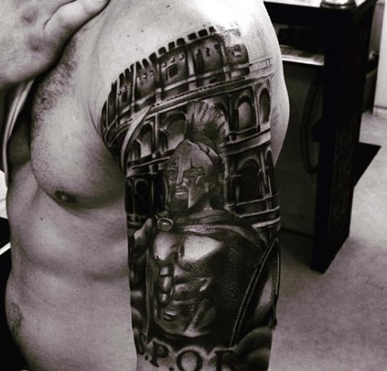 A black and white tattoo of a Roman soldier and the Colosseum with a fierce gladiator on a man's arm