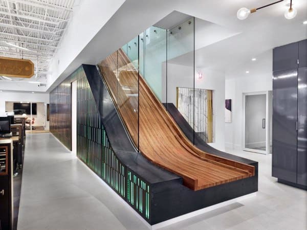 Modern office slide crafted from wood and glass, adjacent to a hallway with bright lighting