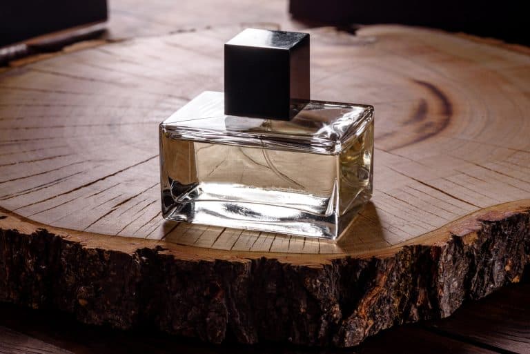 Glass Perfume Bottle on wood stump. How Wearing the Right Perfume Boosts a Man’s Self-Image