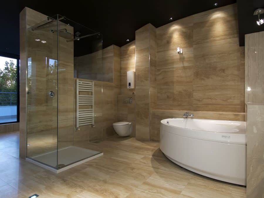 large luxury bathroom with glass shower and white spa