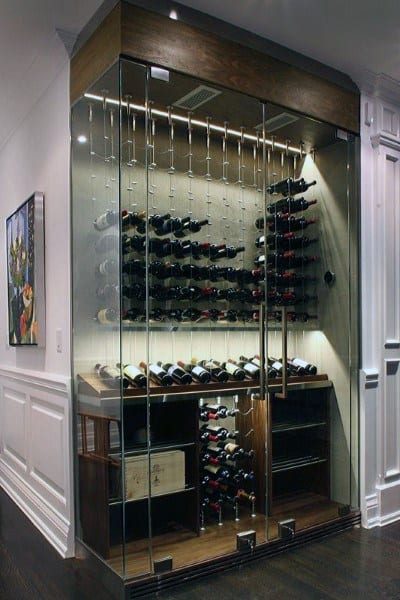 Wine bottles are gracefully displayed in a glass-enclosed cellar within a modern interior