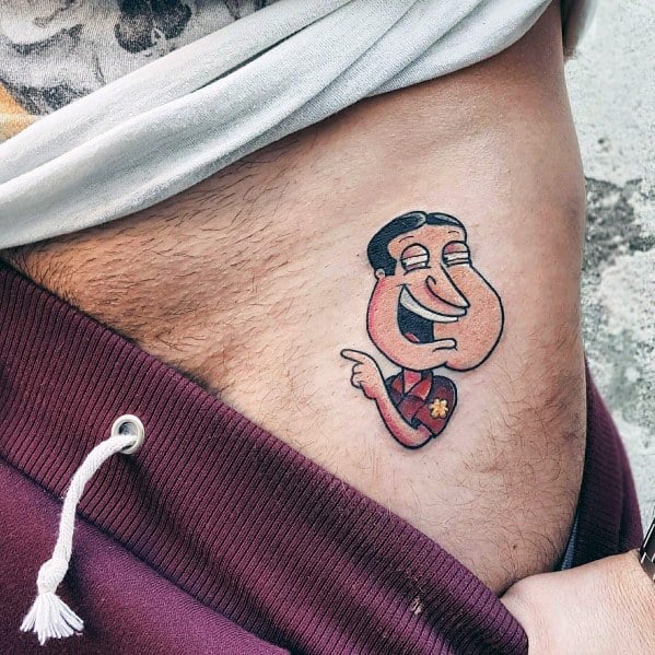 Tattoo of Glenn Quagmire from Family Guy with his signature grin and pointing gesture, placed on the lower abdomen for a humorous effect.