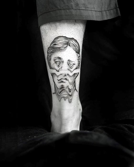 Glitch tattoo of a classical sculpture head with intense horizontal wave distortion through the middle, placed on the back of the leg