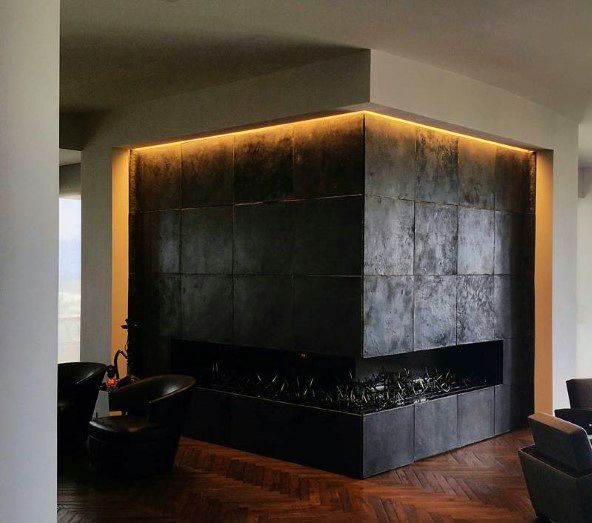 Modern corner fireplace with black tiled surround, LED lighting, and dark wood flooring.