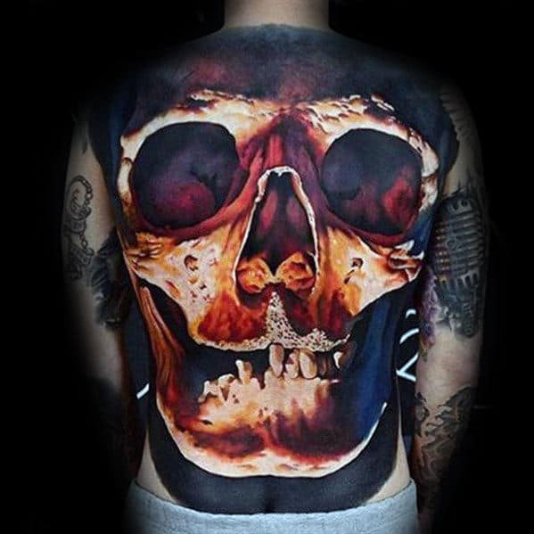 A detailed tattoo of a skull covers a person's back, featuring vibrant reds and dark shadows, creating a dramatic effect